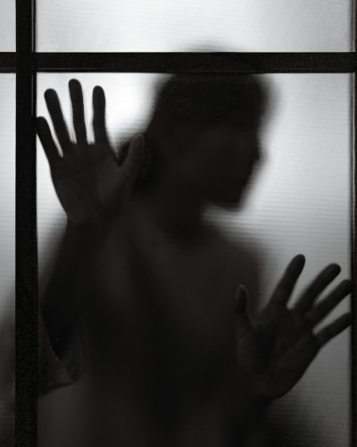 dramatice black and white silhouette of blurred woman shadow behind window glass. concept of depressed and lonely people with fear of darkness